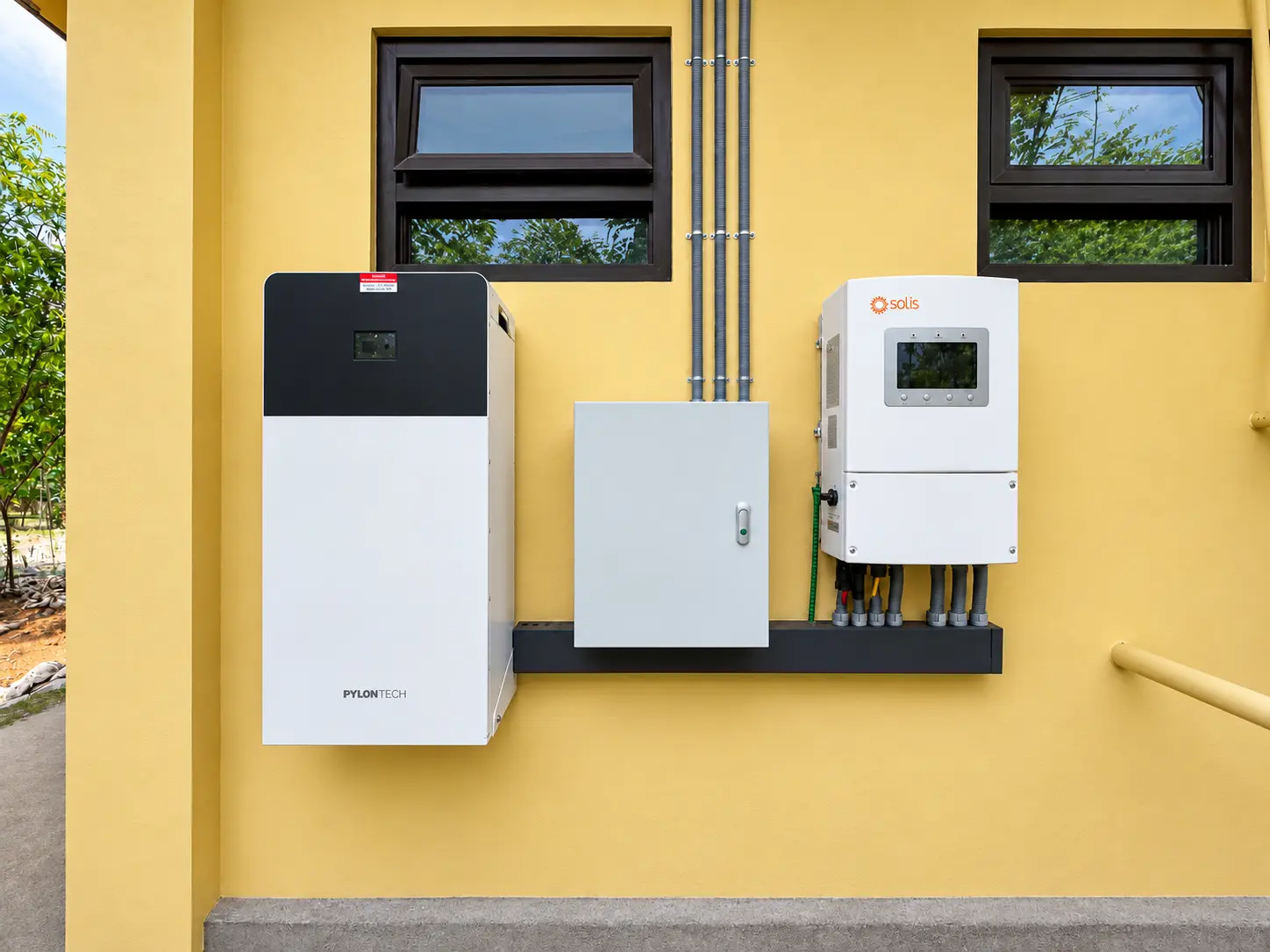 Hybrid solar inverter and battery installation on a yellow exterior wall in Caba, La Union