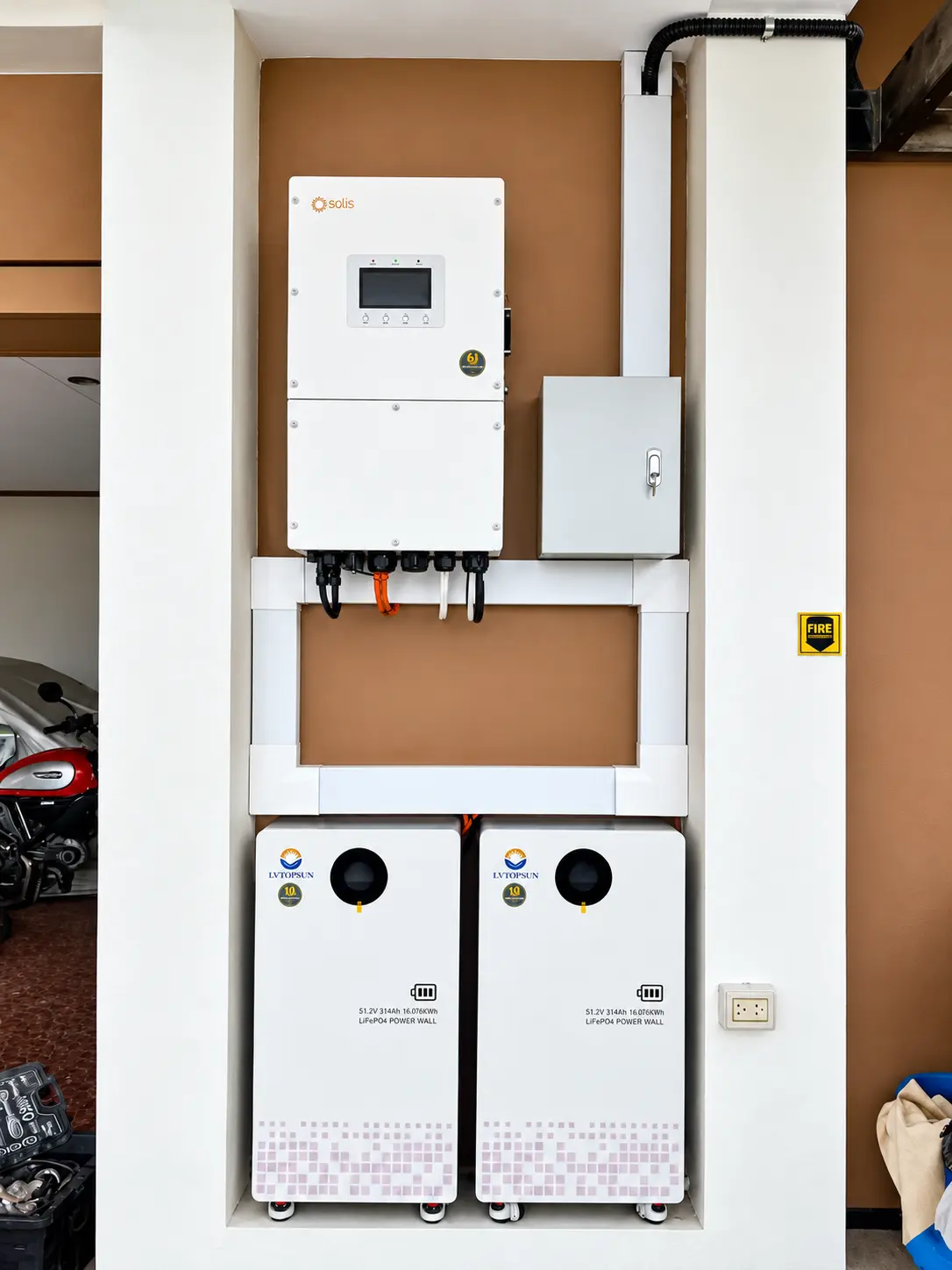 Solis hybrid inverter and two battery cabinets installed on a brown accent wall in Sto. Tomas, Batangas